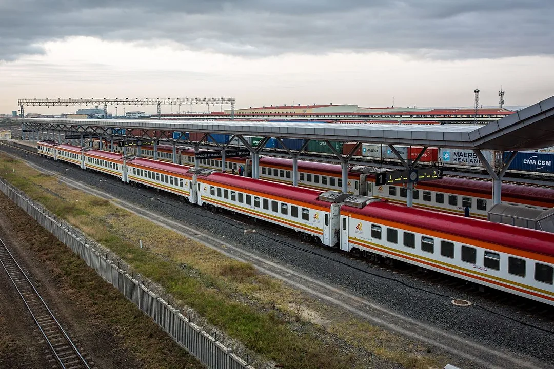ORANGE, RED AND WHITE STRIPED RAIL CARS SIT ON A SERIES OF TRACKS