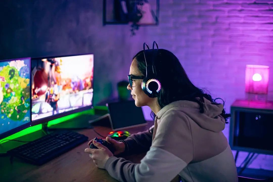 A woman gamer plays online video game on joystick at home at night
