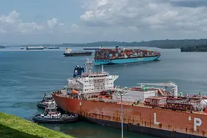 MULTIPLE SHIPS AT SEA IN THE MOUTH OF A LARGE CANAL