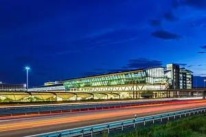 LOW-LYING GLASS AND STEEL BUILDINGS ARE LIT UP AT NIGHT