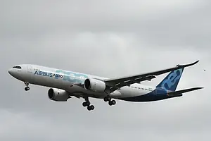 A LARGE AIRCRAFT BEARING THE AIRBUS LOGO FLIES ACROSS THE SKY