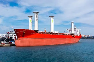 A red tanker vessel with four white masts extending from its deck