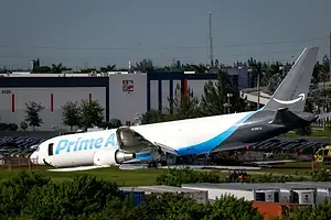 A PLANE BEARING THE PRIME AIR LOGO SITS WITH ITS NOSE IN A DOWN POSITION