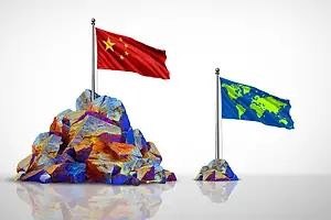 A CHINESE FLAG IS PLANTED IN A PILE OF RARE EARTH MINERALS, NEXT TO A SMALLER PILE WHOSE FLAG SHOWS A MAP OF THE WORLD