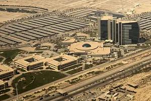 A LARGE COMPLEX OF BUILDINGS SITS IN THE DESERT