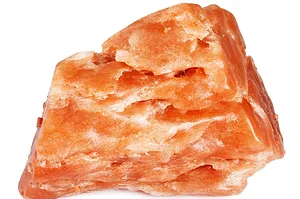 A ROUGHLY CUBE-SHAPED LUMP OF ORANGE CRYSTALLINE ROCK