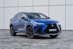 A BLUE CROSSOVER AUTOMOBILE SITS ON A GREY SHOWROOM FLOOR